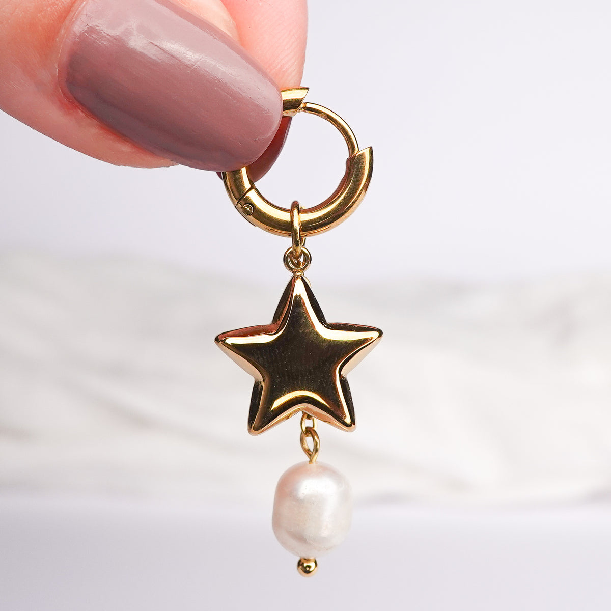 Aros huggie Estrella y perla bañado en oro