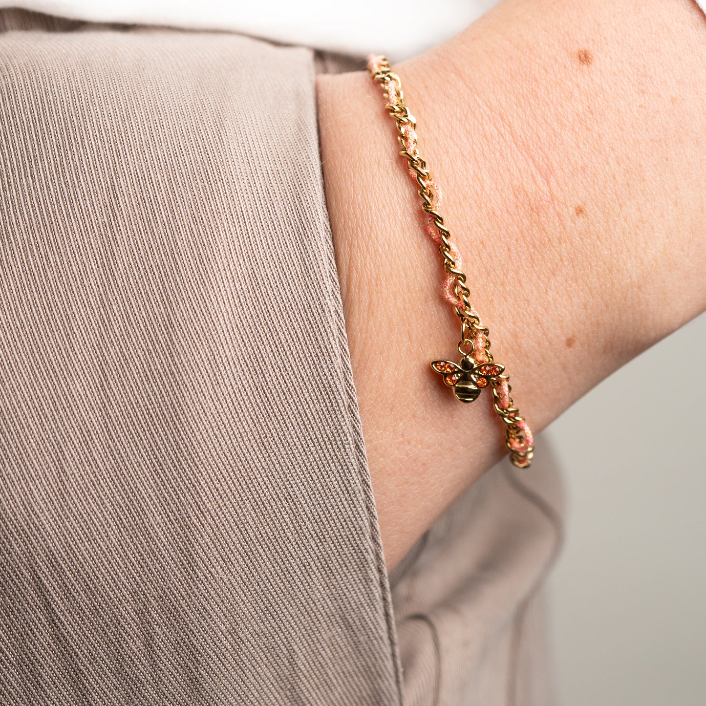 Pulsera de abeja con hilo rosado bañado en oro