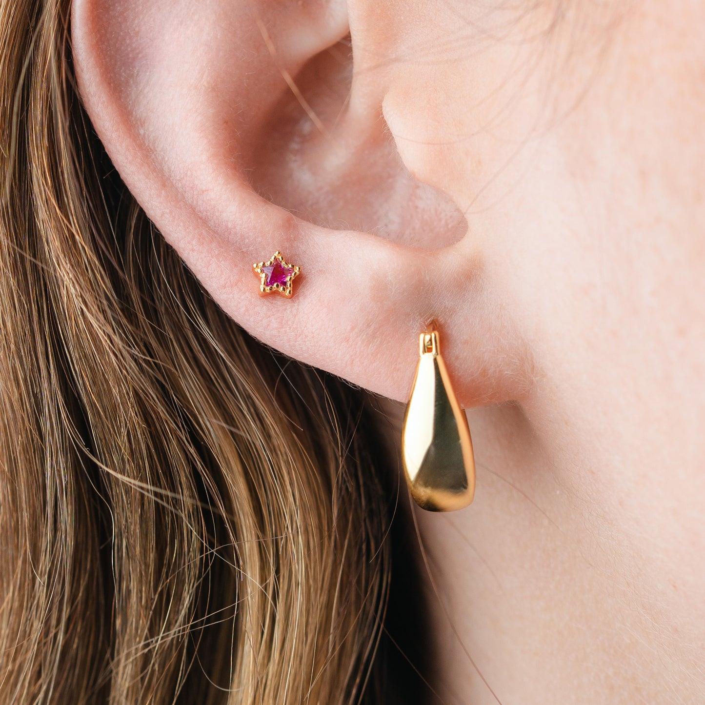 Aros pegados estrella fucsia cierre pelotita bañado en oro