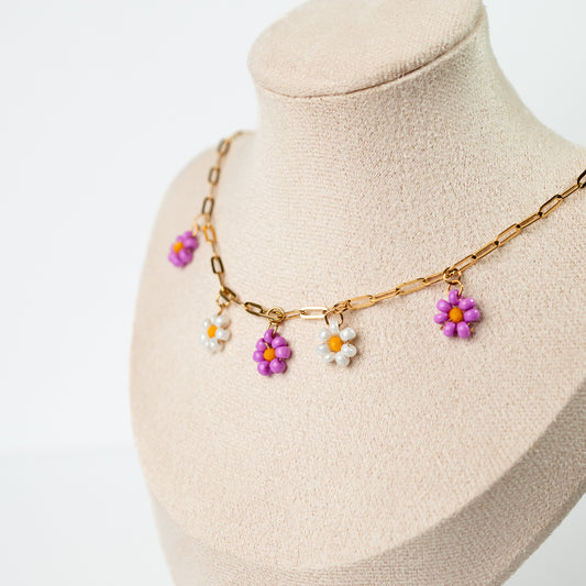 Collar de flores moradas y blancas bañadas en oro