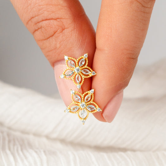 Aros pegados flor de circones celestes bañado en oro